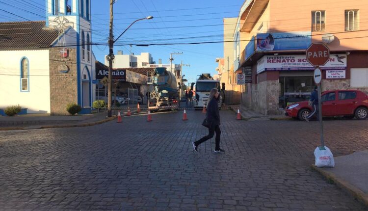 No local estão dois caminhões que auxiliam na construção de um prédio que está sendo erguido em frente ao Alemão Veículos. (